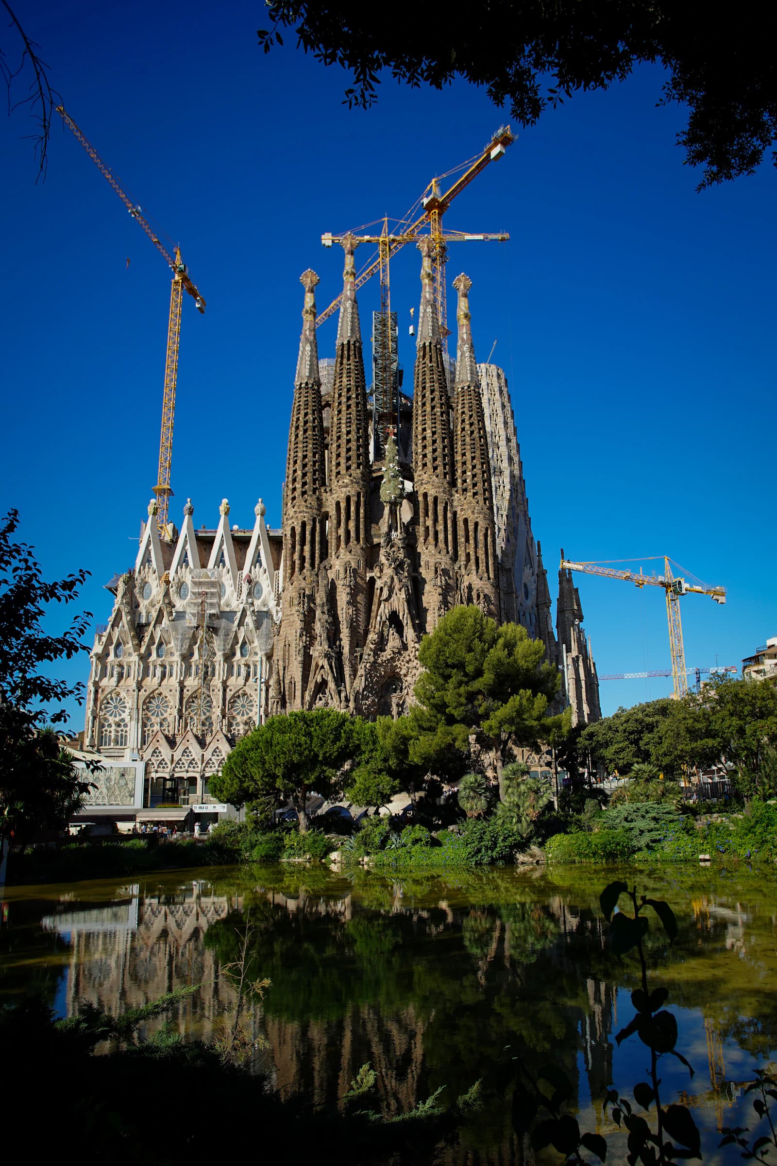 The Sagrada Família Nativity towers reflected in the park’s pond