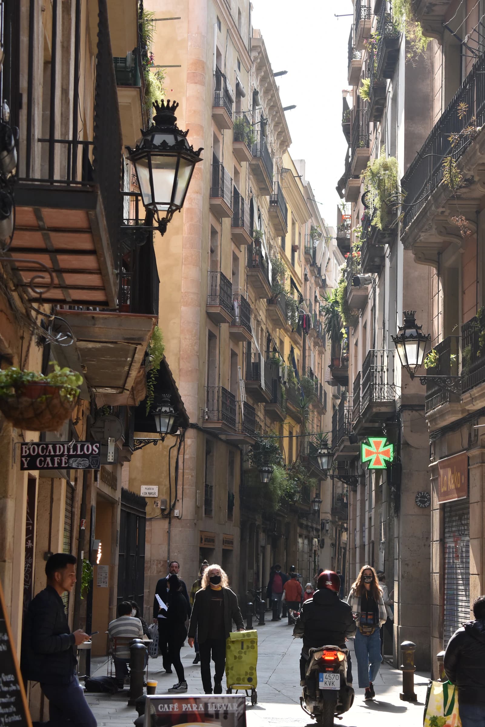 Pedestrians between historic façades in the old streets of Barcelona