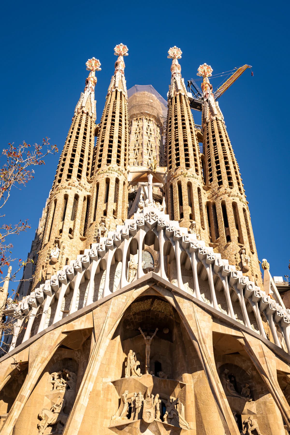 Sunlit towers of the Sagrada Família against a clear blue sky